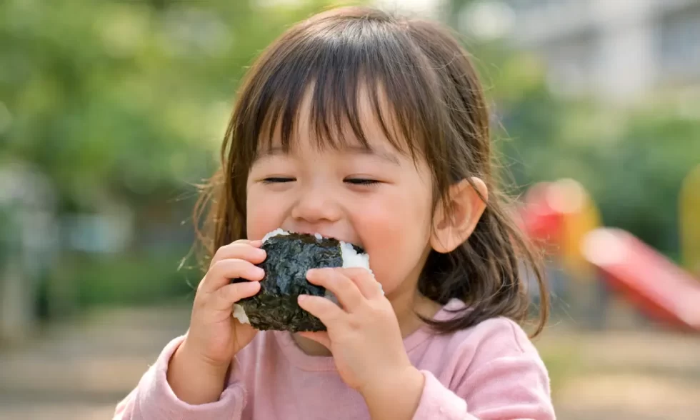 おにぎりを食べる2～3歳くらいの女の子